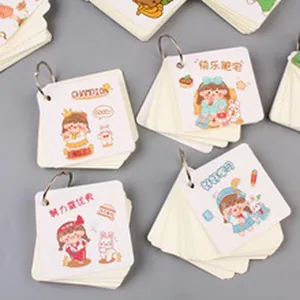 Detailed macro shot of four mini cartoon flip cards with rings on a gray background