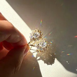 Primer plano detallado de pendientes de moissanita en gota de oro con brillo de arco iris