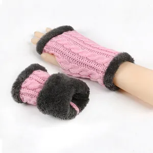 Vue détaillée de mitaines en maille rose avec bordure en fausse fourrure grise pour l'hiver.