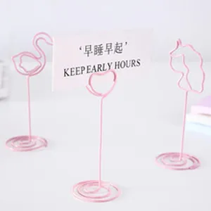 Minimalist pink metal wire place card holders in flamingo and heart shapes for desk photos