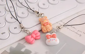 Detailed close-up of cute cartoon resin charms with pink bow, bear and bunny designs