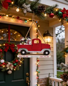 Close-up of a festive wooden red truck Christmas ornament hanging in a cozy porch setting