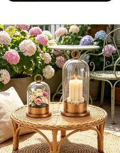 Ensemble de deux élégants bougeoirs en métal doré et verre dans un décor de jardin