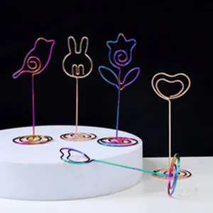 Detailed view of rainbow iridescent metal memo clips in bird, rabbit, and flower shapes