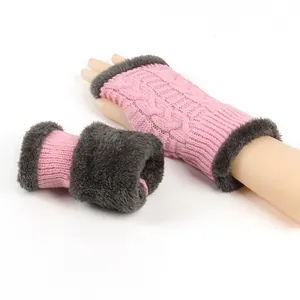 Macro view of pink cable-knit fingerless gloves featuring soft grey faux fur trim and lining