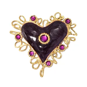 Detailed view of a vintage heart pendant featuring purple enamel and elegant gold wire frame