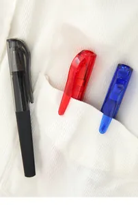 Close-up of three colorful mini gel pens tucked into a white corduroy shirt pocket