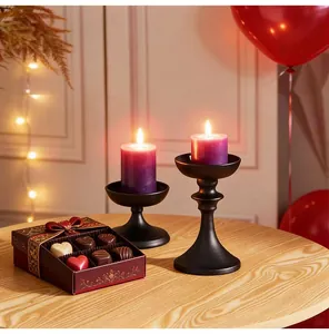 Detail view of retro matte black iron candle holders on a festive wooden table.