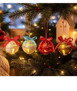 Vista dettagliata di campane di Natale luminose con nastri festivi appese a un albero