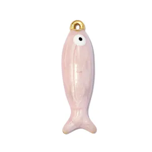 Vista dettagliata di un ciondolo a forma di pesce in smalto rosa con gancio dorato.