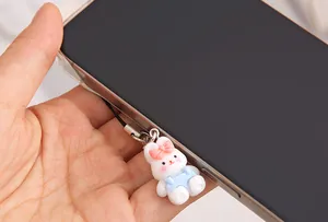 Adorable white resin rabbit phone charm with pink bow detail and blue outfit accessory