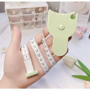 Close-up of a cute cat-shaped green portable body measuring tape held in hand