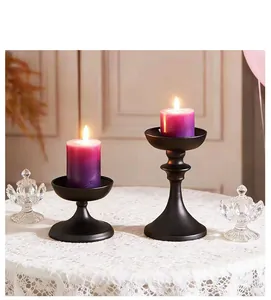 Elegant set of two vintage matte black iron candle holders in different heights on white lace