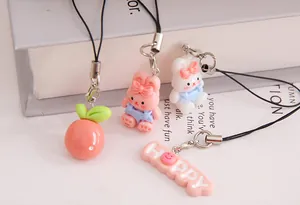 Detailed view of adorable resin rabbit and fruit charms with a HAPPY text pendant