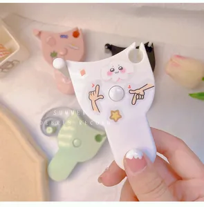 Close-up detail of a cute portable mini tape measure with a white cat-ear handle design