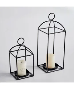 Detalle de modernos portavelas geométricos de hierro negro para decoración hogar