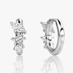 Close-up view of moissanite huggie earrings featuring marquise and baguette cuts