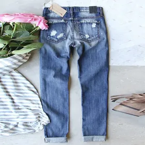 Detailed back view of women's mid-rise straight-leg jeans with distressed pockets and wash effect
