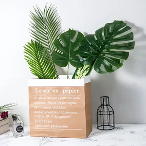 Feuilles de Monstera et de palmier artificielles dans un sac en papier pour déco.