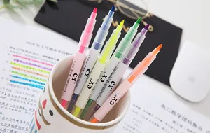 Vibrant 6-color double-headed highlighter set arranged in a ceramic mug on a desk.