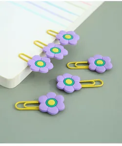 Detailed macro view of creative purple flower-shaped metal paper clips for stationery.