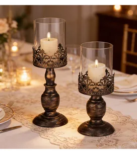 Two vintage bronze candlesticks with glass hurricanes on a romantic dinner table setting