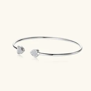 Detailansicht eines Herz-Armreifs aus 925er Sterlingsilber mit funkelnden Moissanit-Steinen.