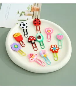Variety of colorful cartoon shaped metal paper clips and creative bookmarks in a tray.