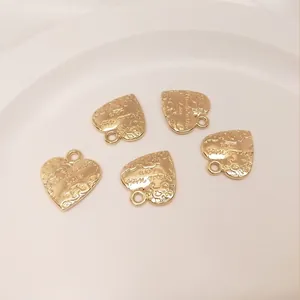 Close-up of 14K gold filled heart charms engraved with Made with Love for DIY jewelry
