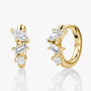 Detail of 14k gold moissanite huggie earrings with marquise, baguette and round stones.