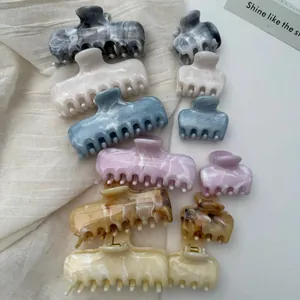 Detailed view of French marble pattern hair claw clips in assorted sizes and colors