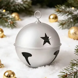 Large silver metallic Christmas bell ornament with star cutouts on snow background