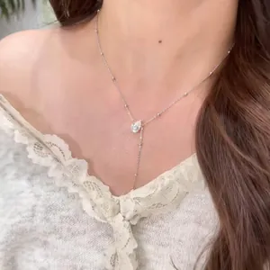 Élégant collier lasso en moissanite argentée avec pendentif poire porté par un mannequin