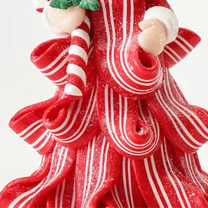 Macro di un ornamento per albero di Natale in argilla polimerica a righe rosse e bianche con glitter