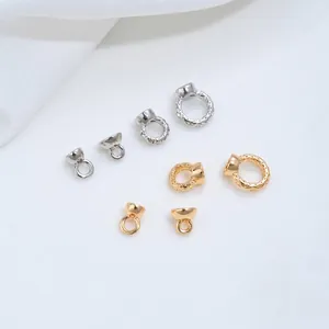 Macro detail of 14K gold-plated twisted pig nose jewelry connectors in gold and silver