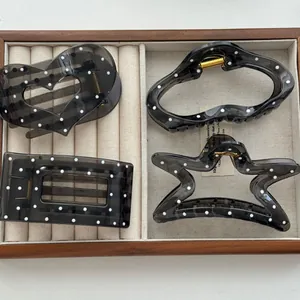 Detailed view of black translucent polka dot hair claws in heart and star shapes