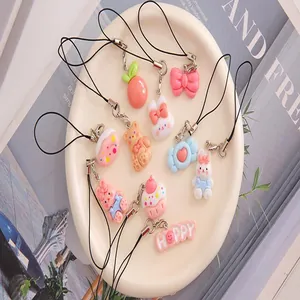 Close-up of cute cartoon resin charms with bunny and cake designs for phone straps.