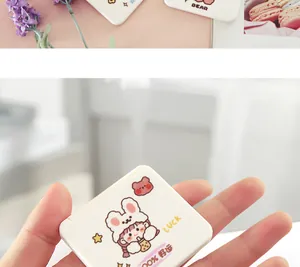Vista de mano de un bonito espejo de maquillaje plegable de dibujos animados con diseño de niña