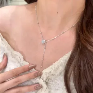 Élégant collier plaqué or 14 carats avec pendentif pompon en moissanite taille poire sur modèle.