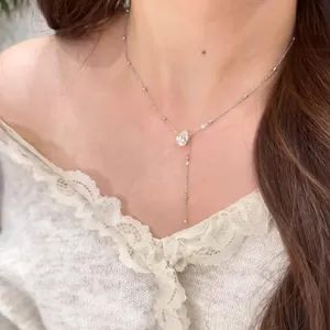 Gros plan d'un élégant collier à gland en moissanite plaqué or blanc 14 carats