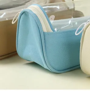 Close-up of the light blue pencil bag showing its transparent top and white zipper detail