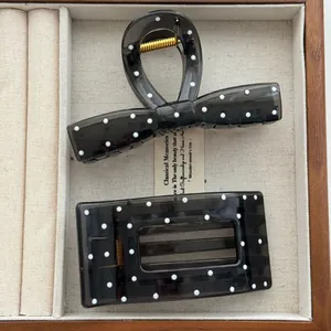 Detail view of semi-transparent black polka dot hair claw clip and rectangle clip set