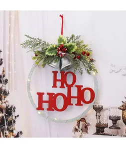 Close-up of Christmas wreath with red HO HO HO letters, pine branches and LED lights.