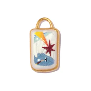 Close-up of stainless steel pendant with colorful elephant and star enamel design.