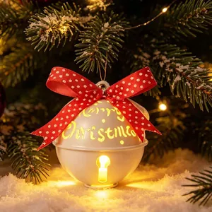 Campana di Natale luminosa bianca con fiocco rosso a pois su un albero di pino