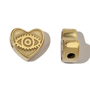 Vue détaillée de la perle en forme de cœur dorée avec motif œil pour bijoux DIY.