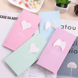 Detail view of colorful pastel hollow greeting cards featuring heart and wing laser cutouts