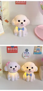 Cute puppy night lights with warm glow on desk with decorative cards and stickers.