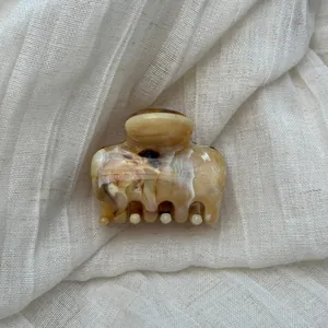 Detail view of a French style hair claw clip with brown marble ink pattern