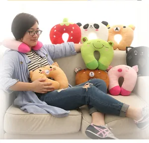 Various cartoon animal plush U-shaped travel neck pillows demonstrated by a model on sofa